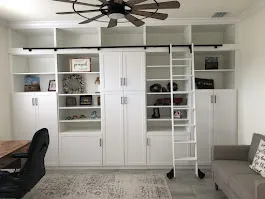 Built in wall unit rolling library ladder — custom storage designed and installed by Dream Closets in Sarasota, FL