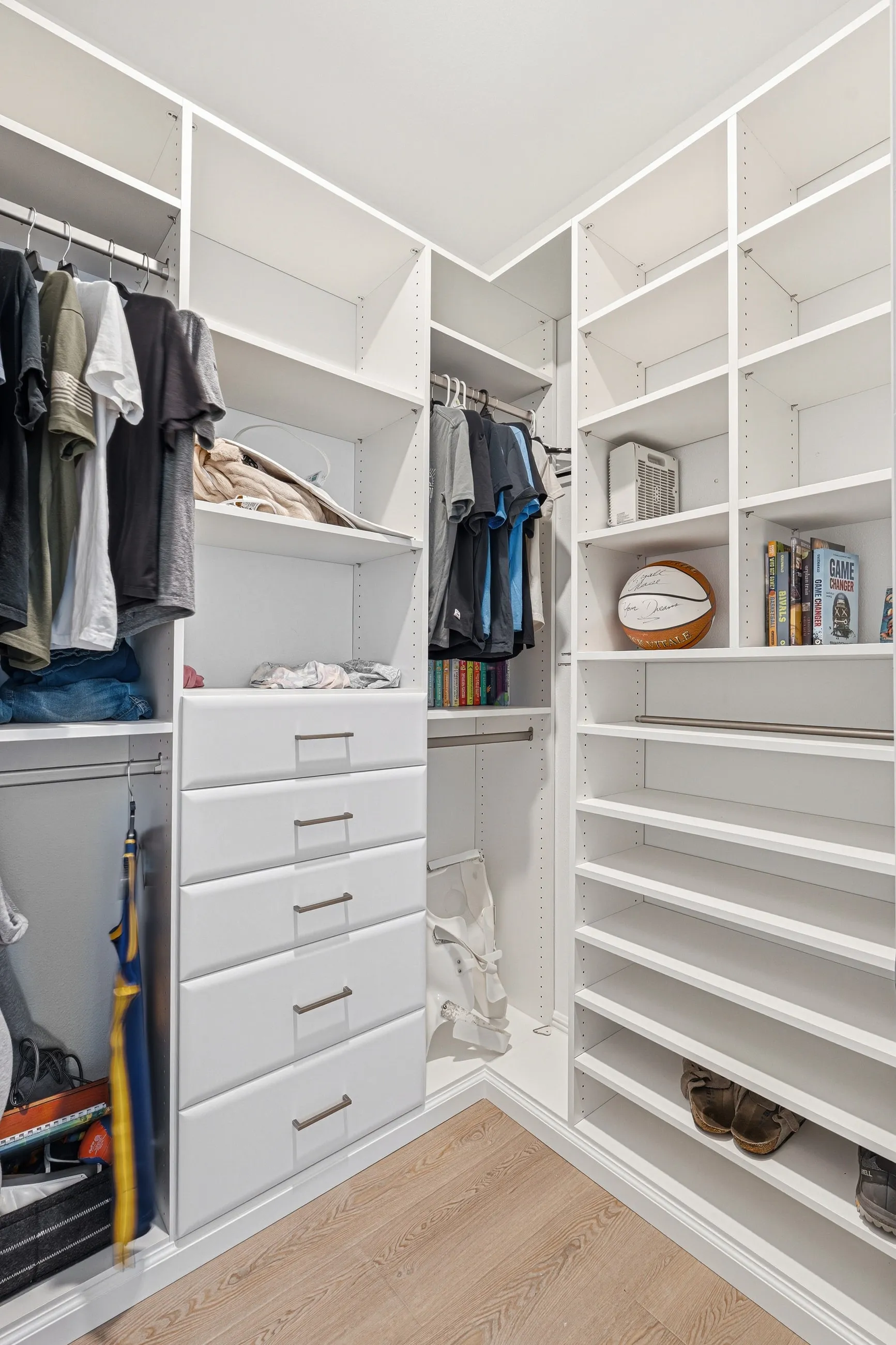 Corner walk-in closet with open shelving and angled shoe storage in Bradenton, FL