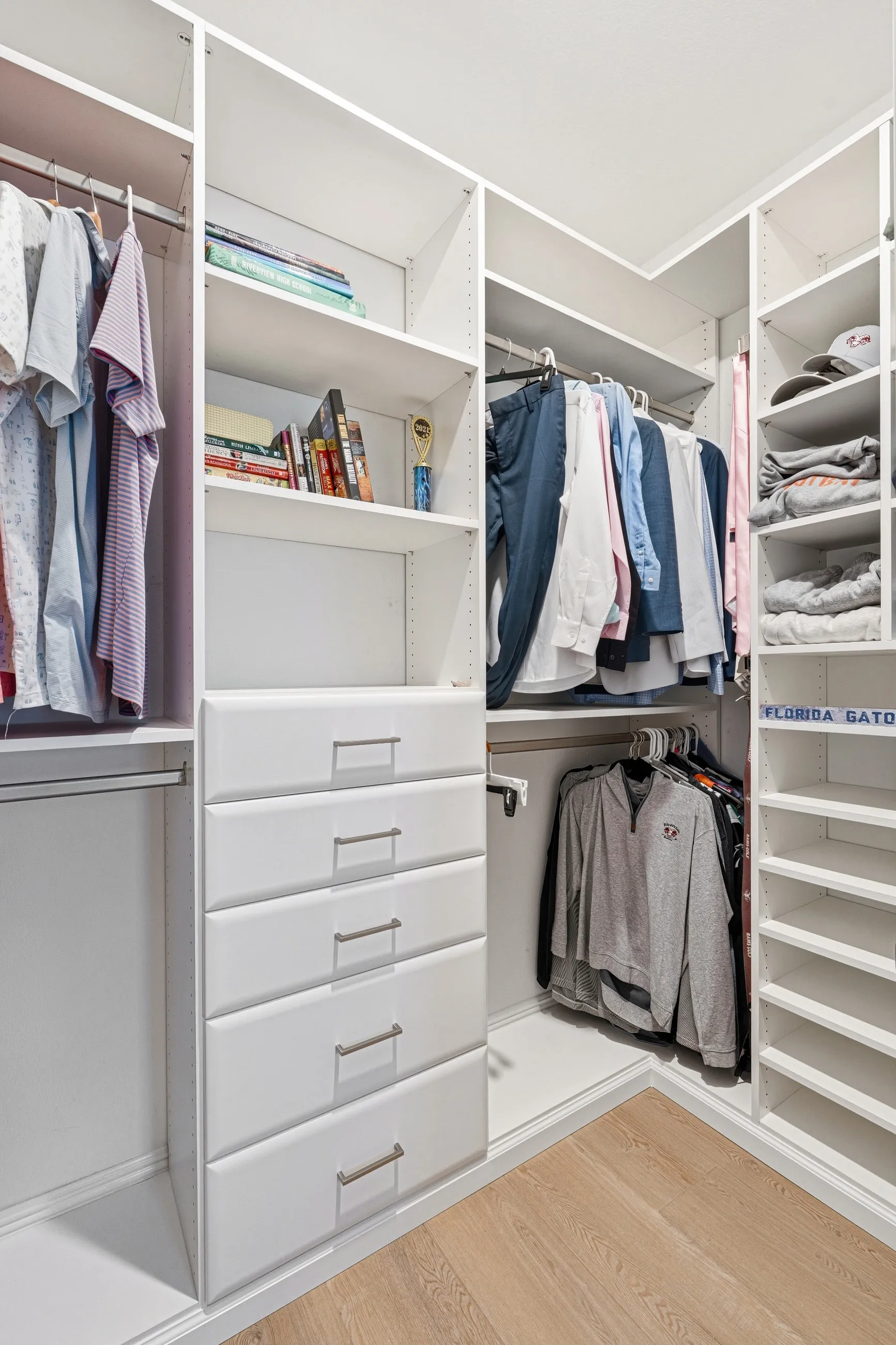 Custom reach-in closet with dual hanging rods and a central drawer tower in Bradenton, FL