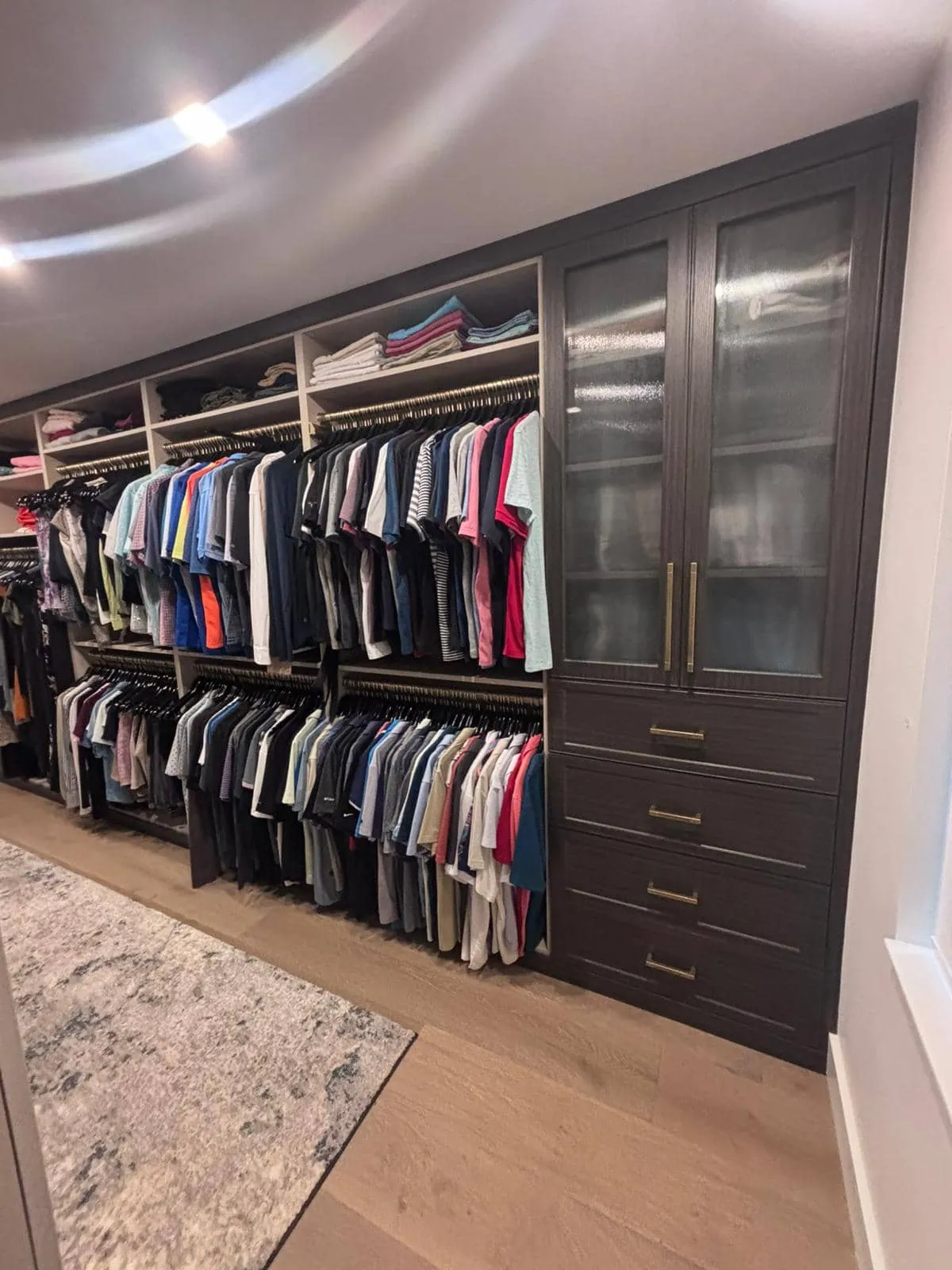 Walk-in closet with espresso cabinetry and antique brass hardware in Longboat Key, FL
