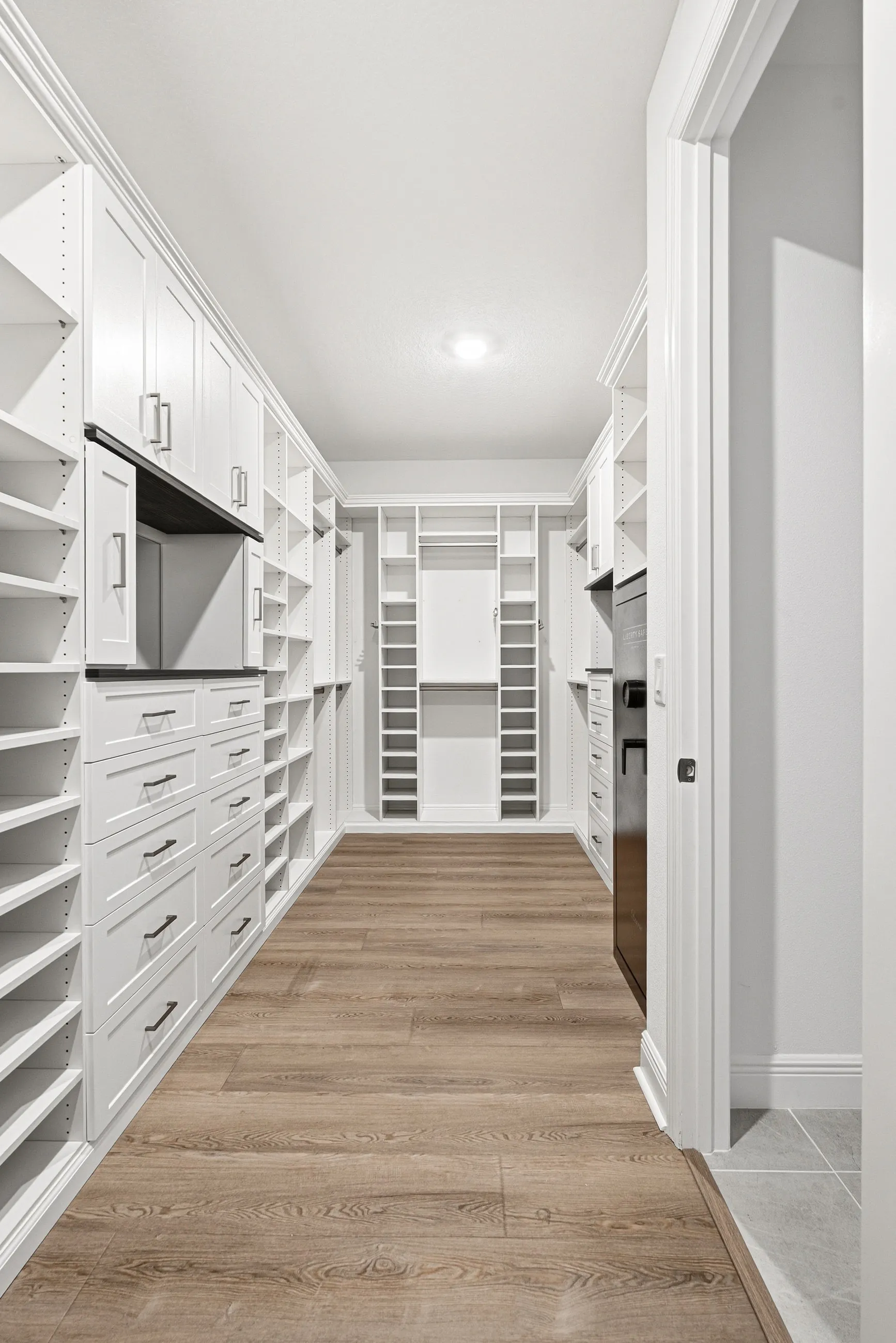 Walk-in closet hallway view with dual-wall shelving by Dream Closets in Bradenton, FL