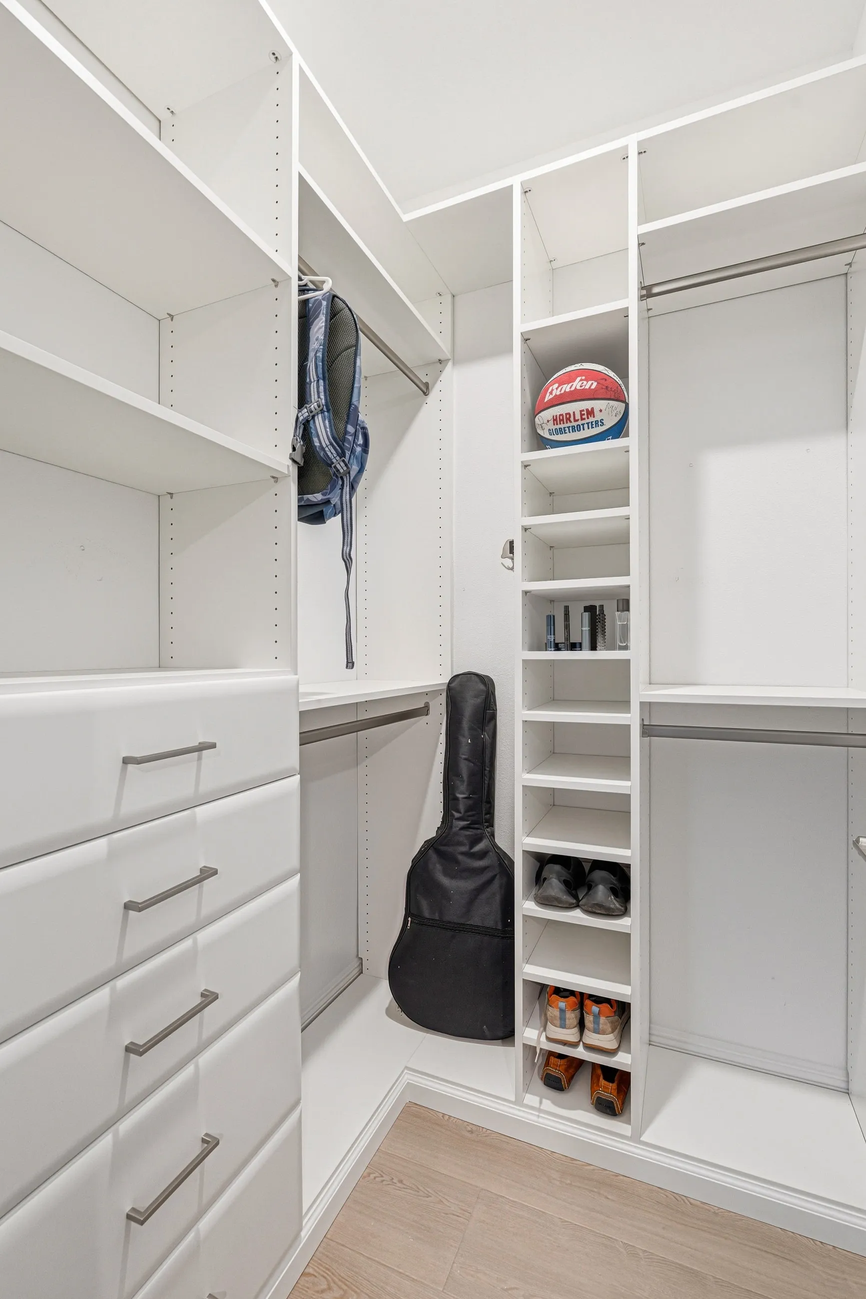 Walk in closet shoe storage corner organization — custom storage designed and installed by Dream Closets in Bradenton, FL