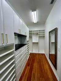 Walk in closet upper cabinets gold hardware — custom storage designed and installed by Dream Closets in Lakewood Ranch, FL